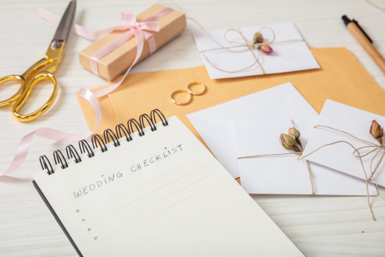 Flat lay and close up view of checklist and wedding invitations