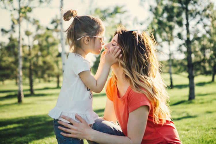 Mother hugs her daughter.