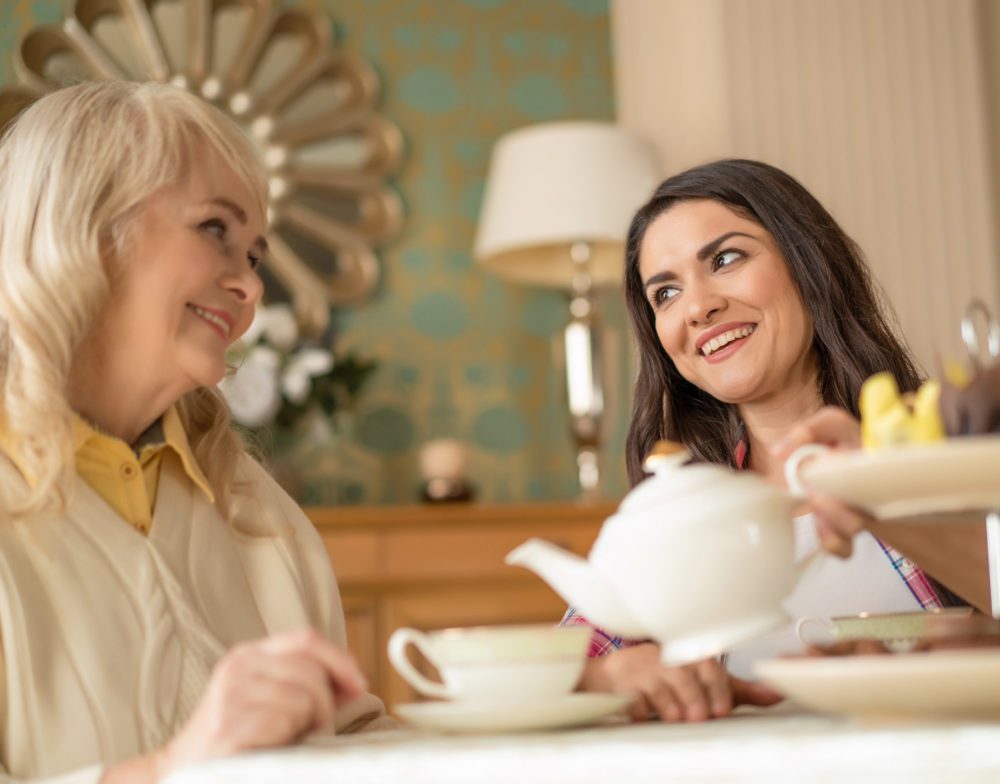 Nice conversation between senior mother and daughter over cup of tea