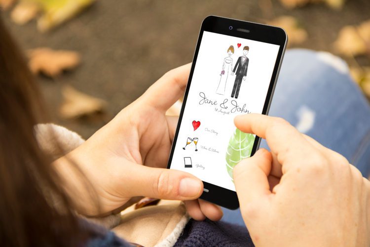woman with cool wedding invitation design phone in the park